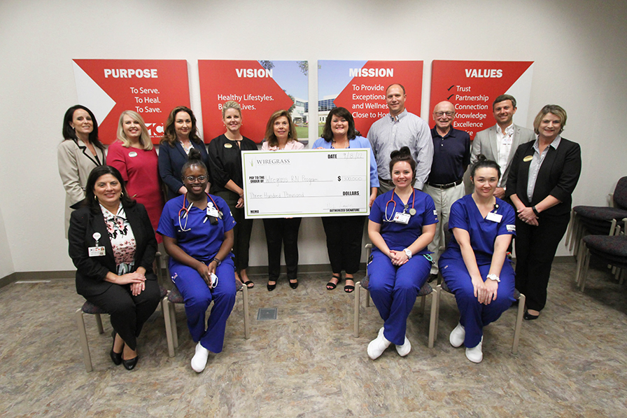 WGTC and CRMC staff, holding a check