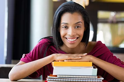 Smiling black female with stack of books